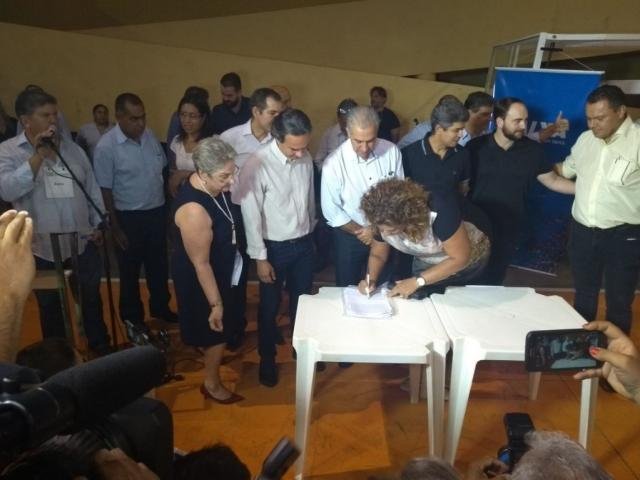 Prefeito Marquinhos Trad e o governador Reinaldo Azambuja assistem a assinatura de contrato de uma das contempladas (Foto: Divulgação)